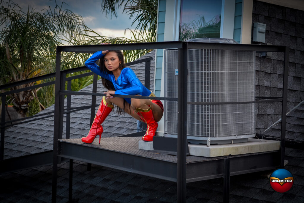 Brii Zee as UltraGirl, crouching on a rooftop platform beside an air-conditioning unit