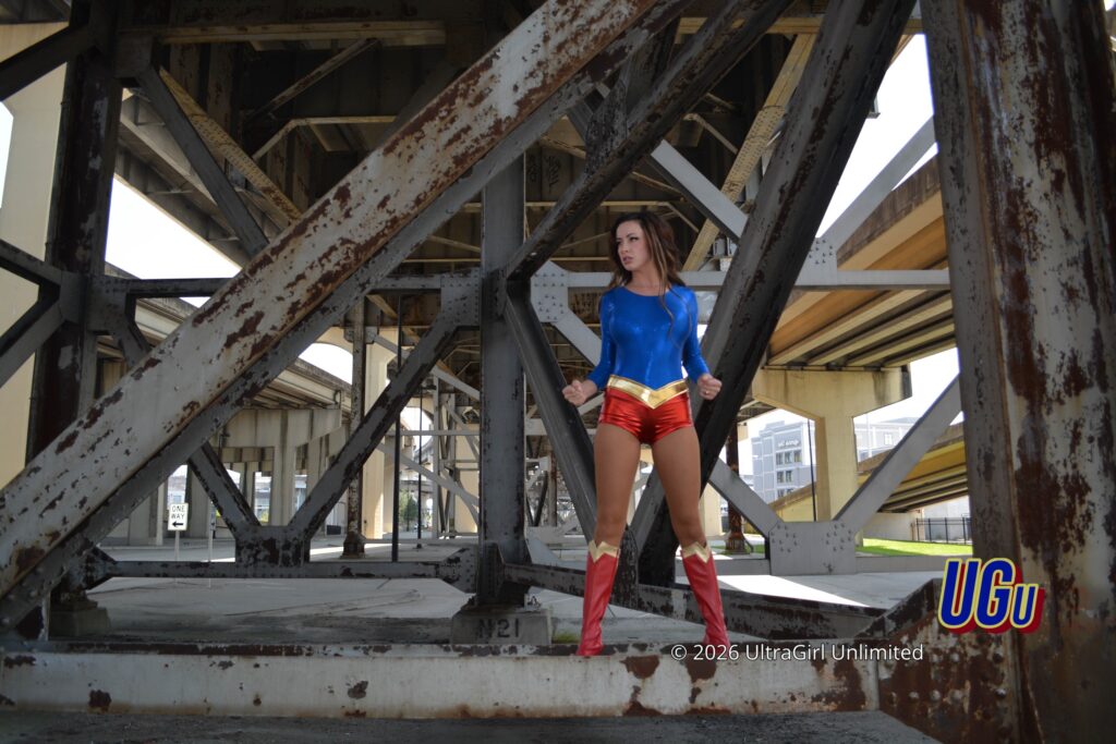 Ophelia Bloom as UltraGirl, standing under the rusted steelwork of a bridge